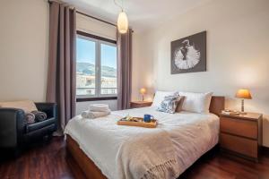 a bedroom with a bed with a tray of food on it at Maderia Emotions I, By OP in Funchal