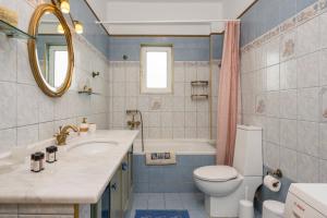 Un baño con lavabo, inodoro y bañera. en Maison Evelyn, en Tsikalariá 29 fotos más