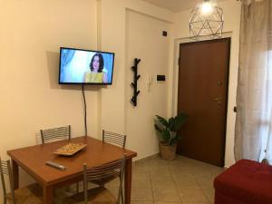 a living room with a table and a tv on the wall at Casa di Nicla in Terni