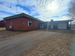 a brick house with a garage on a dirt road at Koivukuja in Kokkola