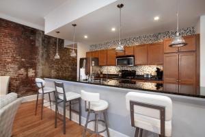 a kitchen with a bar with white stools at The Quiet Old City Hideout in Knoxville