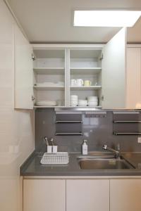 a kitchen with white cabinets and a sink and a sink at Hotel With in Busan