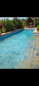 a large pool of blue water with a gazebo at Villa CasaGrande in Ukunda Airport