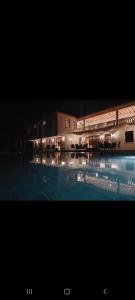 a large building with a swimming pool at night at Villa CasaGrande in Ukunda Airport