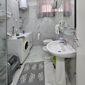 a bathroom with a sink and a washing machine at La piccola gemma in Saviano +35 photos