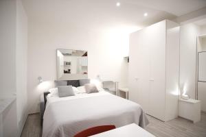 a white bedroom with a bed and a mirror at Cinque Terre Bridge in La Spezia