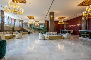 a lobby with couches and chandeliers at Panorama Lisi Grand Hotel in Tbilisi City