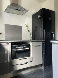 Appart au pied du T2 La Défense Paris في بيزونس: مطبخ مع موقد وثلاجة