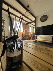 Appart au pied du T2 La Défense Paris في بيزونس: مزهرية بها أعواد جلوس على طاولة