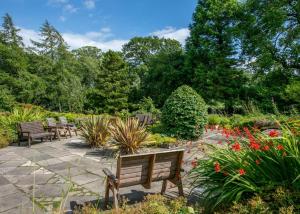 a bench in a garden with flowers and plants at Blaithwaite Country House Estate in Wigton
