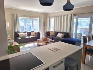 a living room with a couch and a table at Waves Edge at 14 Bridge Waters in Jeffreys Bay