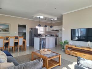 a living room with a couch and a table at Waves Edge at 14 Bridge Waters in Jeffreys Bay