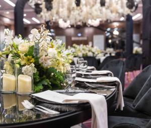 a table with plates and glasses and flowers on it at Crowne Plaza Amman by IHG in Amman