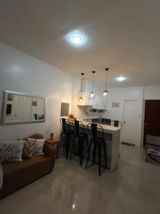 a living room and kitchen with a couch and a bar at Rapha's Place Joy - A in Bacolod