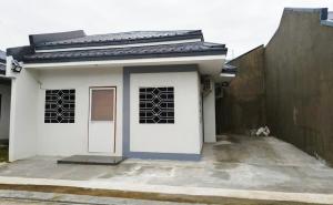 a small white house with a door and a fence at Rapha's Place Joy - A in Bacolod +1 photo