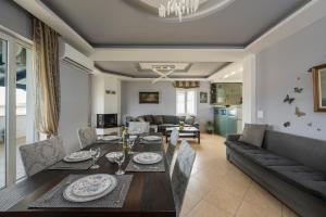 Una sala de estar con una mesa de comedor y un sofá. en Maison Evelyn, en Tsikalariá