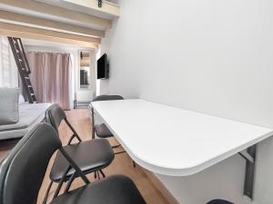 una sala riunioni con tavolo e sedie bianchi di Studio Lumineux Mezzanine à 10 minutes de Disney a Serris
