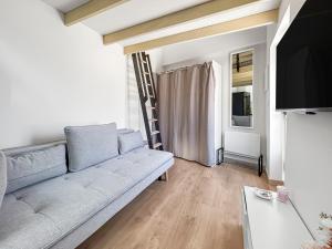 un soggiorno con divano e TV a schermo piatto di Studio Lumineux Mezzanine à 10 minutes de Disney a Serris