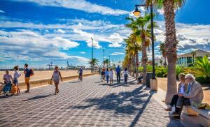 un grupo de personas caminando por una acera cerca de la playa en Beach Room Valencia, NETFLIX, 4 mins walk to the beach, en Valencia