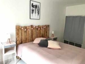 a bedroom with a large bed with a wooden headboard at Charmant Gîte à Neufchâteau Proche Domrémy-la-Pucelle - FR-1-589-797 in Neufchâteau