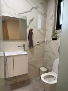 エイラットにあるUrban Suite Neve Tzedek Eilatの白いトイレと洗面台のあるバスルーム +5枚の写真