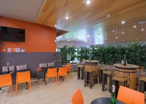 a restaurant with a bar with orange chairs and tables at Fell End in Milnthorpe