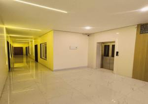 an empty hallway of a building with yellow and white walls at Hotel R.Raghavam in Ayodhya