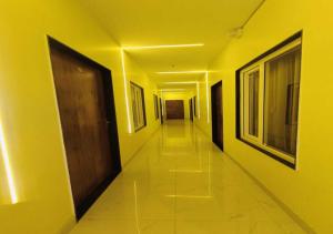 a hallway with yellow walls and a wooden door at Hotel R.Raghavam in Ayodhya