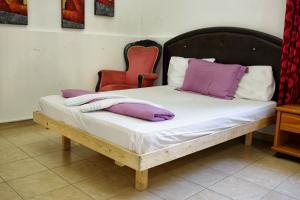 a bed with purple and white pillows on it at City Center Apartments in Haifa