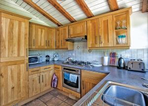 a kitchen with wooden cabinets and a sink at Great Wood Lodges in Flaxton