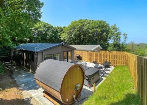 a tiny house in a yard with a fence at Hamlet Lodge Retreat At Calloose Holiday Park in Hayle