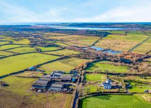 an aerial view of a large house in a field at Glan Morfa Lodge Retreat in Newborough +89 photos