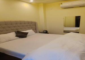 a large white bed in a room with a mirror at Hotel R.Raghavam in Ayodhya