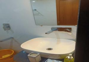 a bathroom with a white sink and a mirror at Hotel R.Raghavam in Ayodhya +17 photos