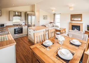 una cocina y una sala de estar con una mesa con platos. en Holderness Country Park, en Tunstall