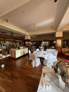 a restaurant with white tables and chairs in a room at Hotel Uckermark in Prenzlau