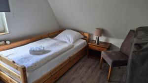 Un pequeño dormitorio con una cama y una silla. en Haus Seerose, en Lalendorf