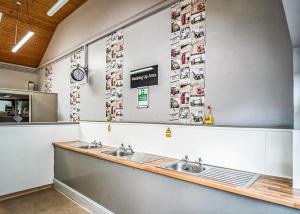 una cocina con 2 lavabos y cuadros en la pared en Lee Valley Sewardstone, en Enfield Lock