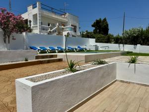 a white house with blue lounge chairs in a yard at Retama Somhome Peñiscola in Peñíscola
