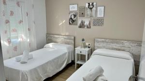 two beds in a room with white walls at Retama Somhome Peñiscola in Peñíscola +20 photos