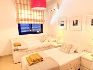 deux lits dans une chambre blanche avec une fenêtre dans l'établissement Cozy Corner Close to Beach, Golf and Shopping, à San Bartolomé 81 autres photos