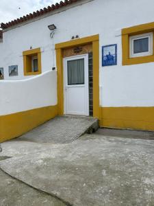 a white and yellow building with a door at Casa Fernando Casquinha in Vila Franca de Xira