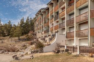 an apartment building with a spiral staircase in front of it at Alpazur 2 - Proche des remontées mécaniques in Gréolières