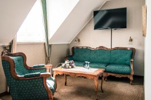 a living room with a green couch and a table at Haus Thal in Overath