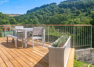 a wooden deck with a table and chairs on it at Millendreath Beach Resort in Looe