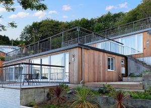 a house with a large balcony on the side of it at Millendreath Beach Resort in Looe