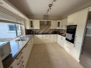 a kitchen with white cabinets and a sink at Carhan River Holiday Home - Cahersiveen in Cahersiveen