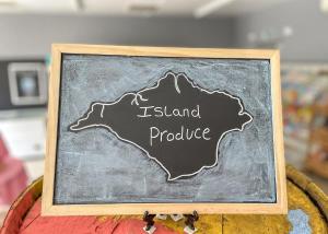 a chalkboard with the name of island produce on it at Orchards Holiday Park in Newbridge