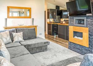 a living room with a couch and a flat screen tv at Ocean Heights Holiday Park in New Quay