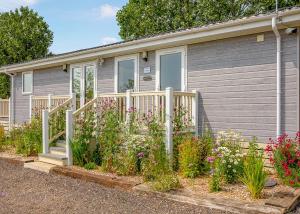 a house with flowers in front of it at Otters Mead Boutique Lodges in Beetley +36 photos